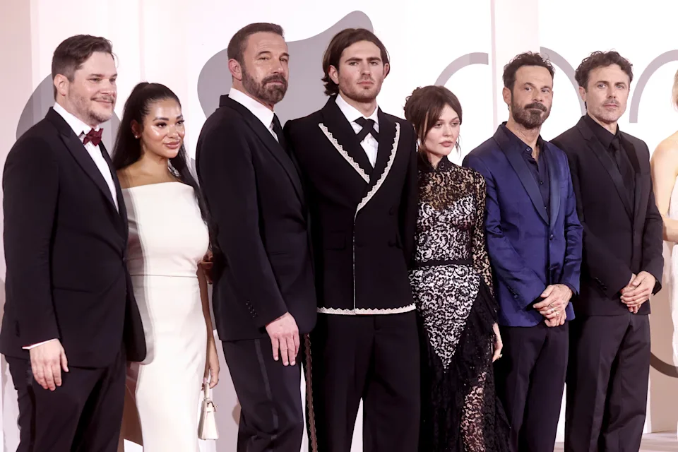 Group of people in formal attire posing on a red carpet