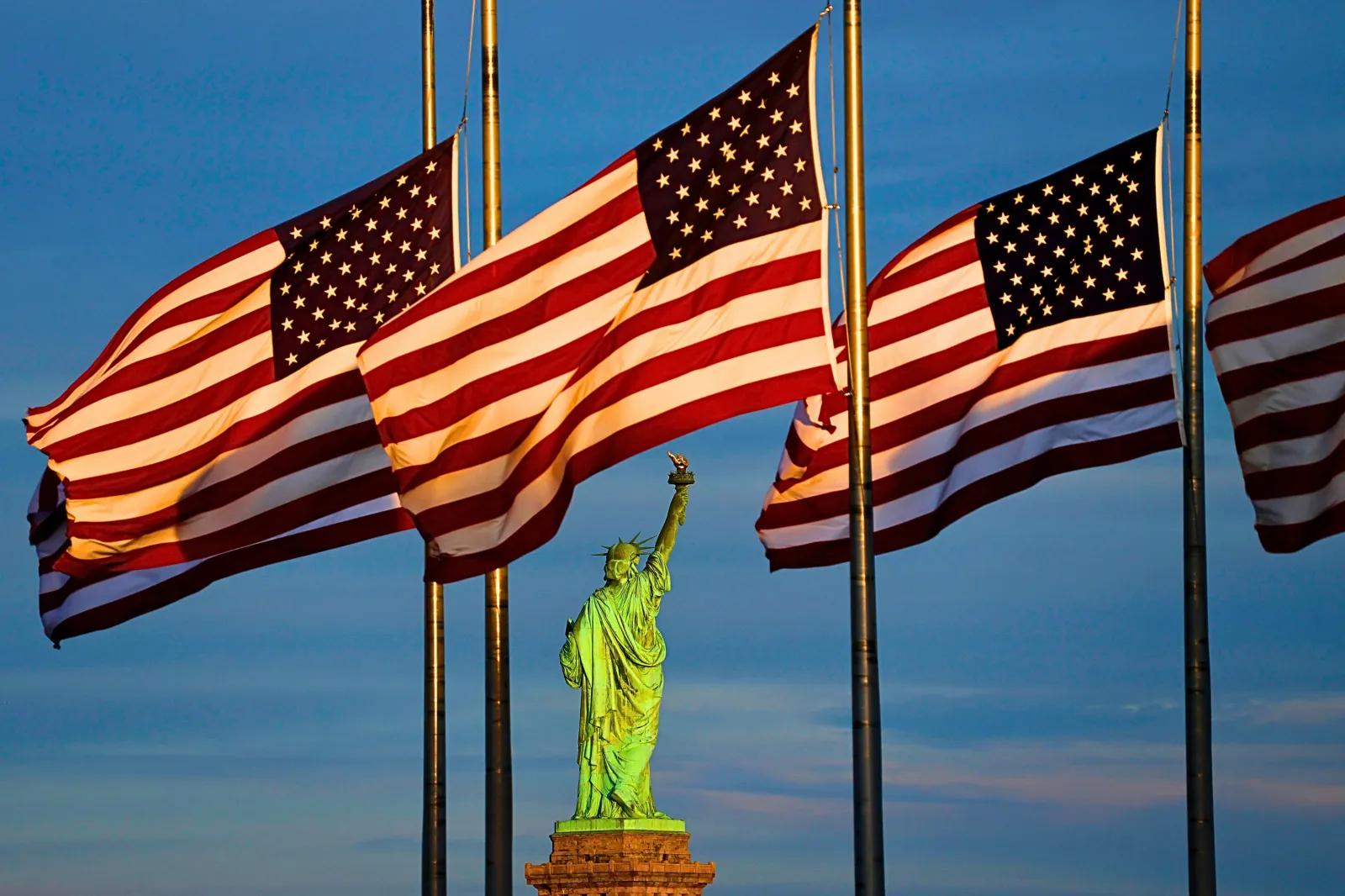 File image: The sun sets on the Statue of Liberty in New York City as flags in the Liberty State Park flag plaza fly at half mast honoring the victims of the school shooting earlier in the week in Minneapolis, Minnesota, on August 31, 2025, in Jersey City, New Jersey.