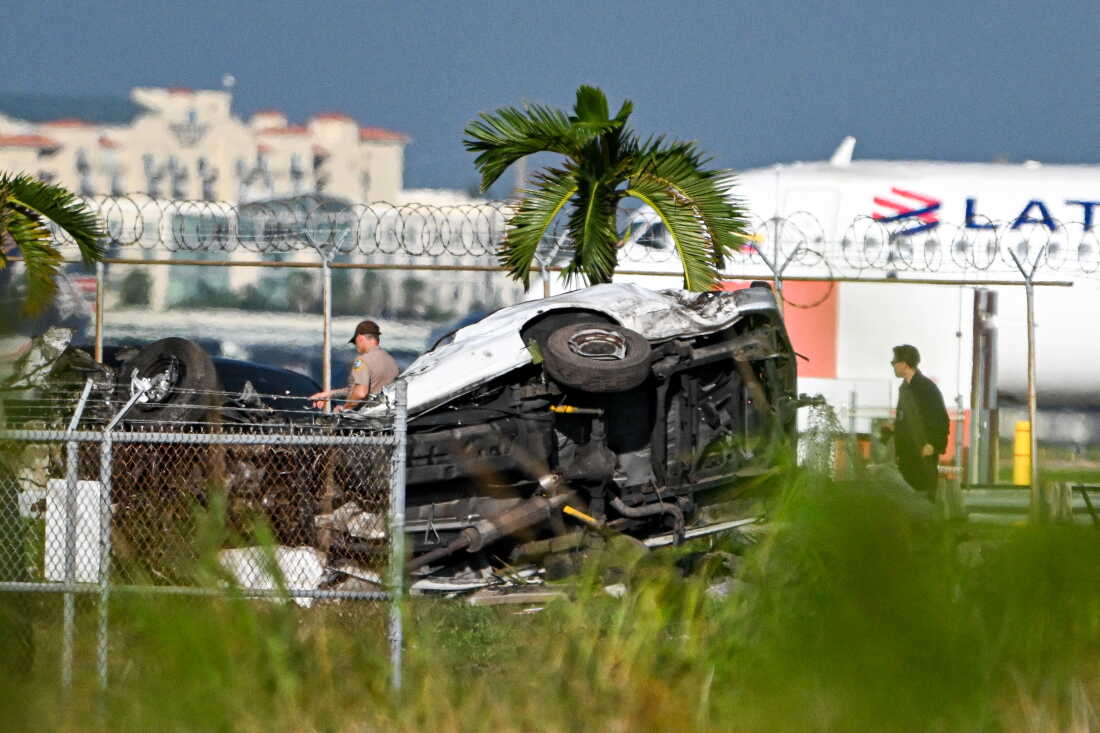 Officials investigate the scene where cars were damaged after a Prime Air cargo plane overran the runway and struck vehicles at Miami International Airport in Miami on September 6, 2026.