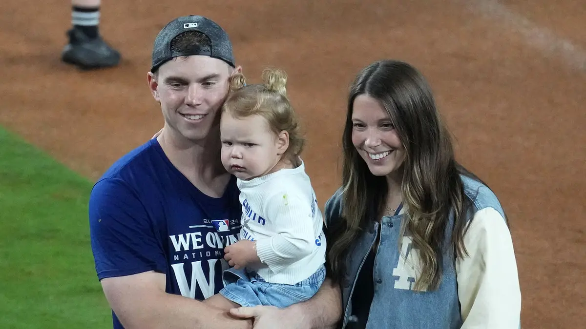 Will Smith poses with his wife Cara Smith and daughter after a Dodgers game at Dodger Stadium.
