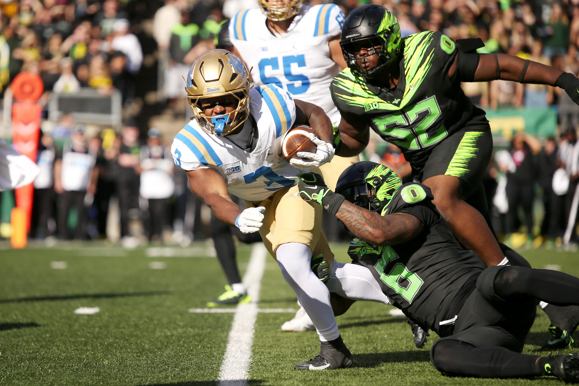 UCLA running back Wayne Knight attempts to pull away from Oregon linebacker Jerry Mixon Saturday in Eugene, Ore. 