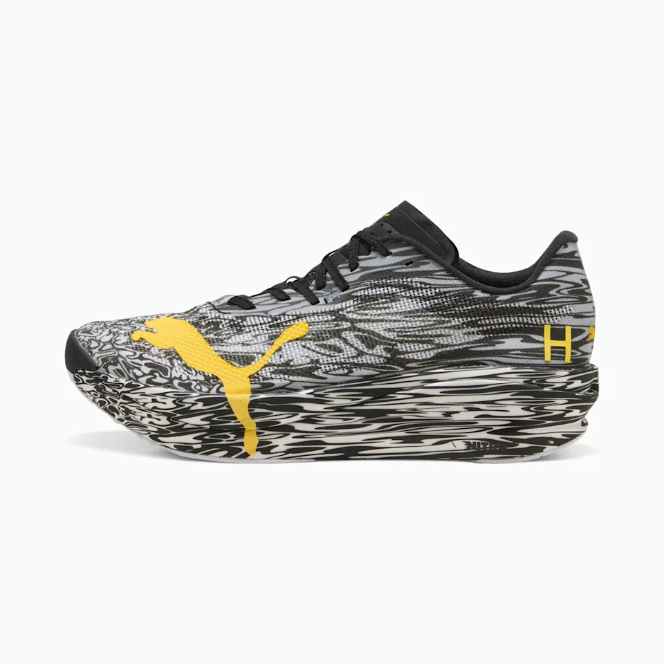 Puma running shoe featuring a black and white marbled pattern, a yellow Puma logo on the side, and black laces.