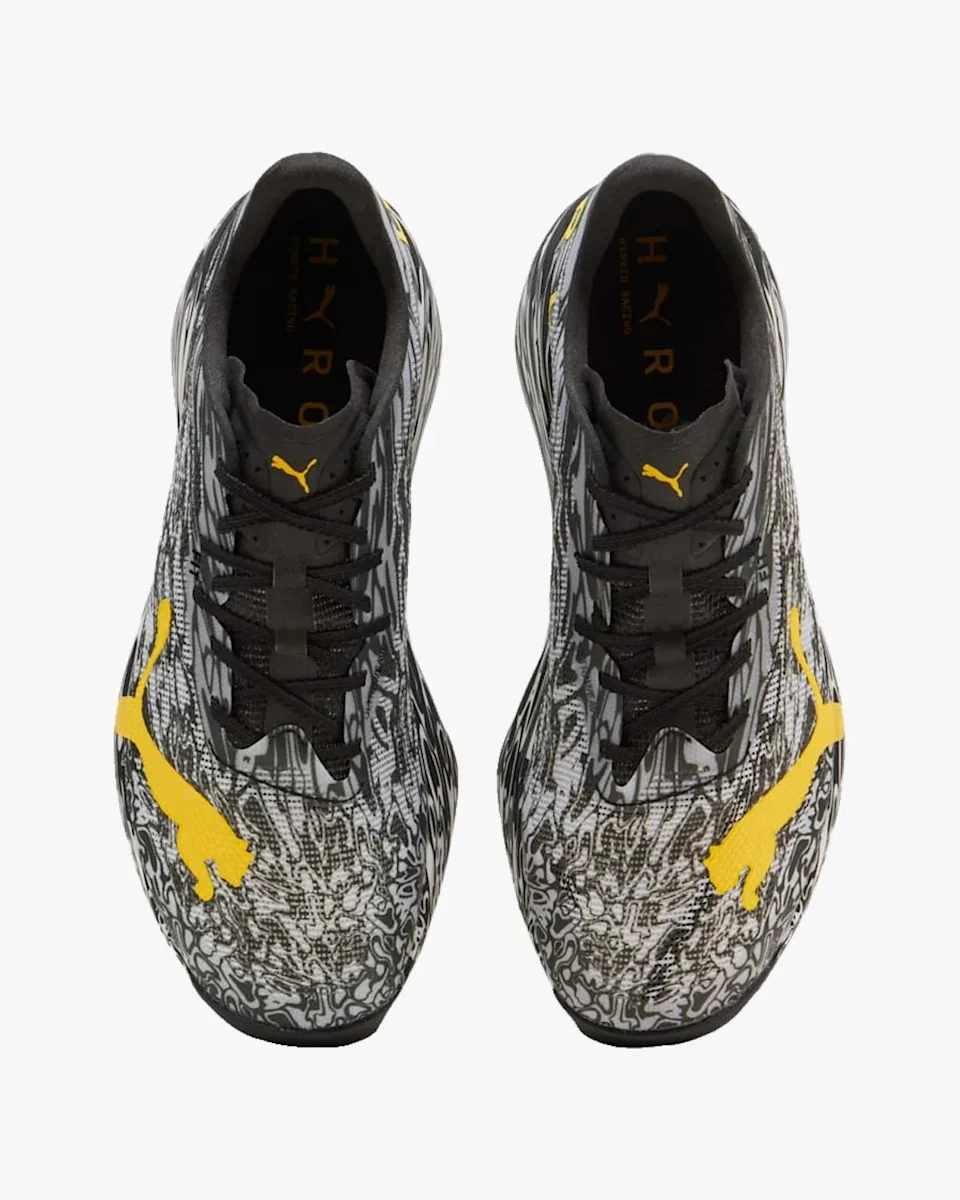 Pair of black and grey patterned Puma sneakers featuring yellow logos.