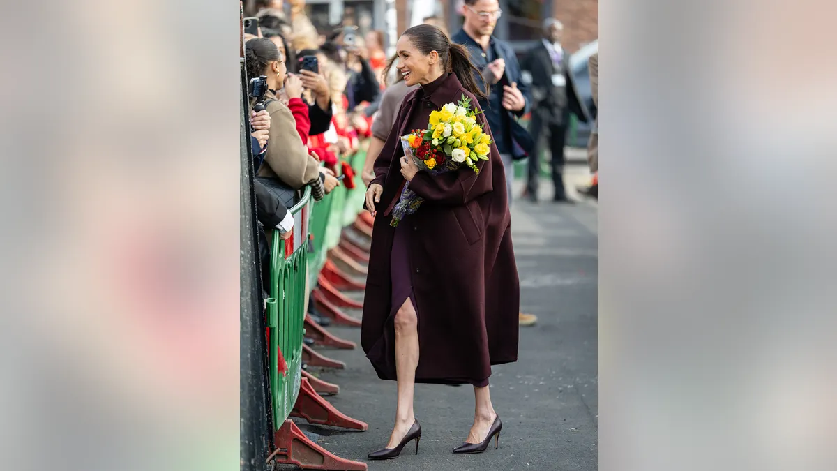 Meghan Markle holding flowers at Nottingham.