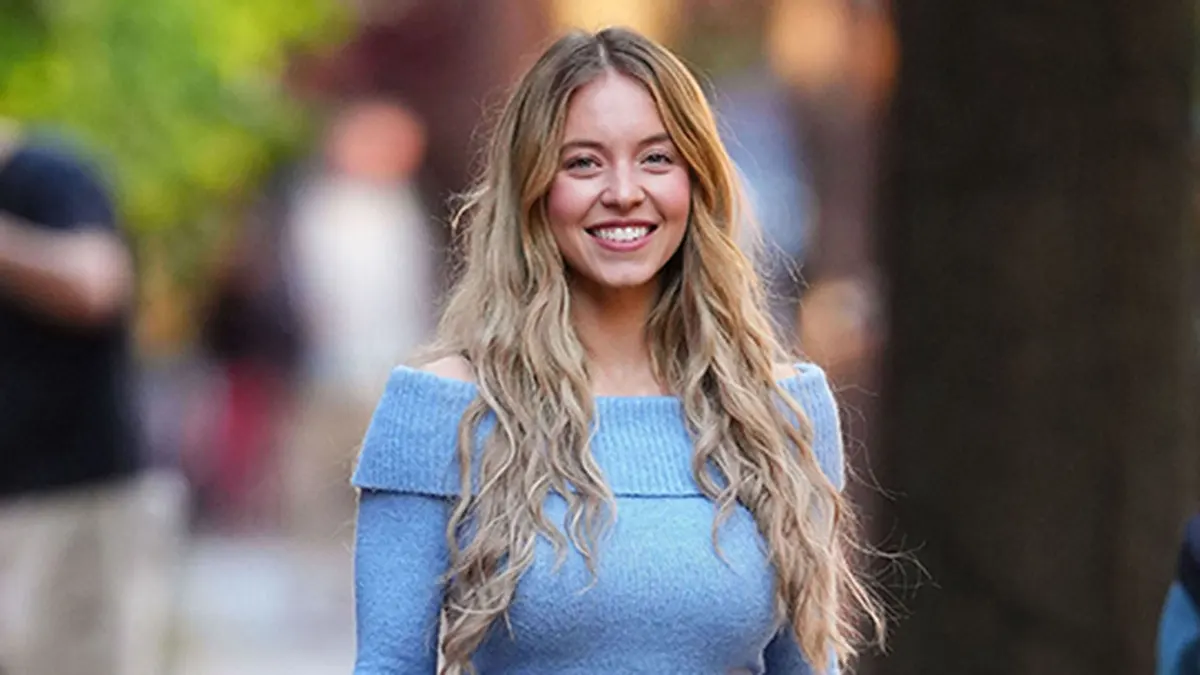 Sydney Sweeney stands on the set