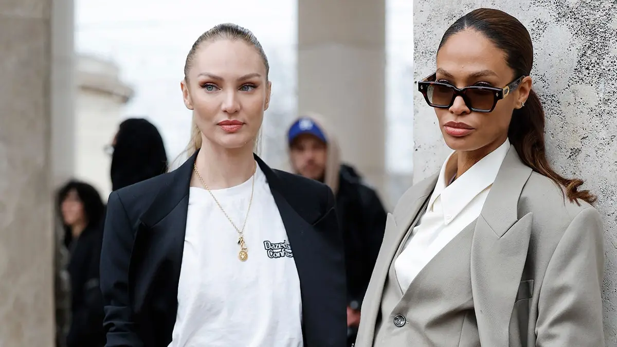 Candice Swanepoel and Joan Smalls stand outside Elie Saab during Paris Fashion Week.