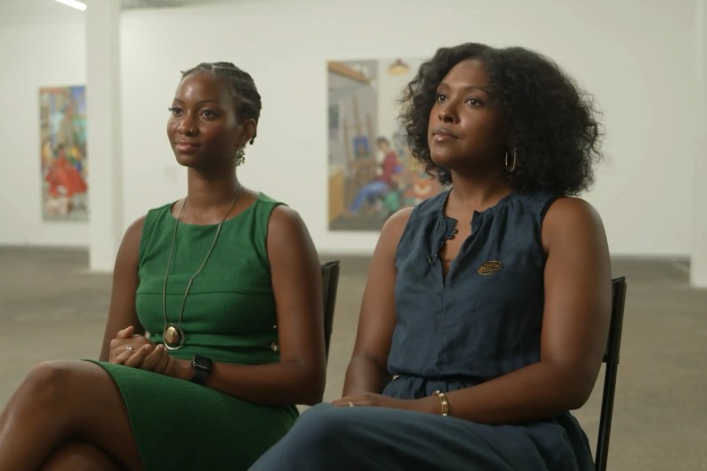 two women sitting in an art gallery