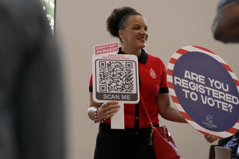 a woman holding a sign that reads